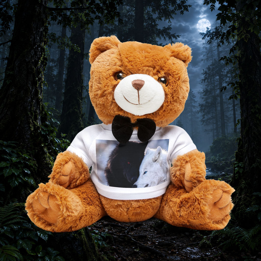 A large brown plush teddy bear sits in a dark forest scene, wearing a white T-shirt with a black bow tie and a printed photo of a black and white dog on the chest.